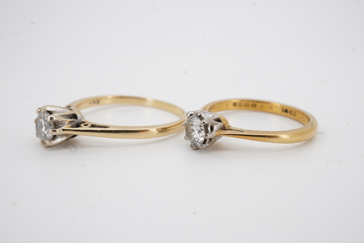 An early 1970's 18ct gold and claw set solitaire diamond ring, size K/L, the stone weighing approx. 0.33ct, together with a yellow metal and solitaire diamond ring, the stone weighing approx. 0.50ct, size P/Q, gross weig